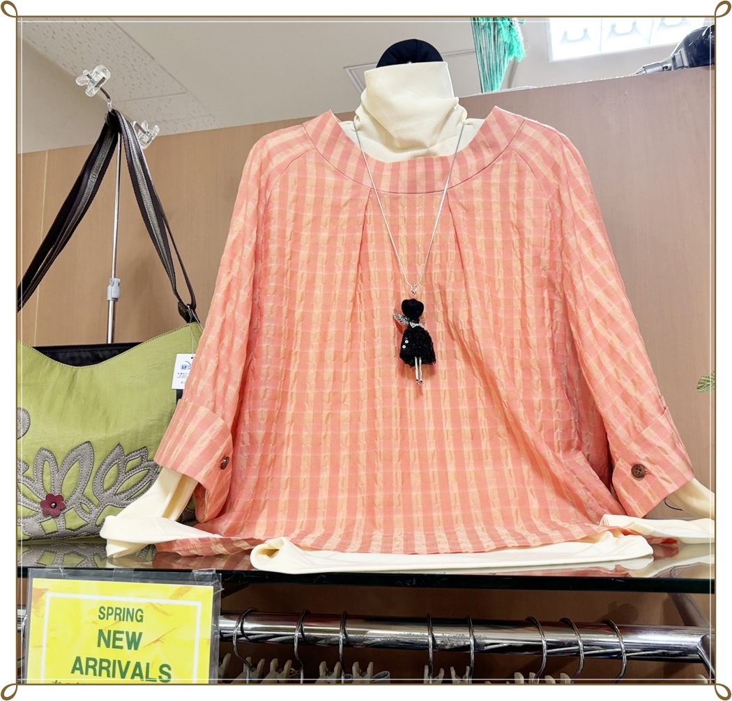 ピンク系チェック柄トップスと白インナーを合わせた春らしい婦人服コーデ