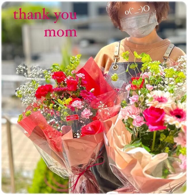 母の日用の花束を持つフラワーショップKAZのスタッフ