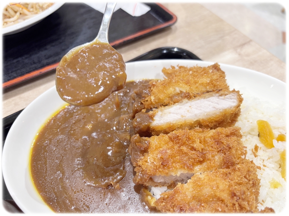 さと家 カツカレーにカレーをかける様子