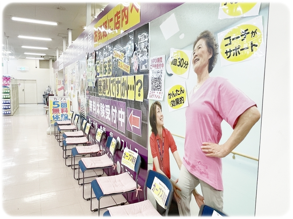 女性コーチが運動をサポートしているカーブス店内