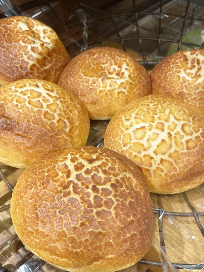 ダブルチーズフォンデュ。ひび割れ模様のある、こんがり焼けた丸いパン